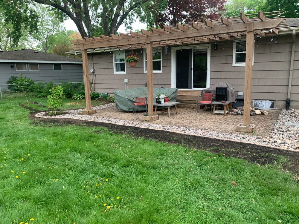 Completed Backyard Drainage and Gravel Channel — After Completed backyard drainage system with gravel channel bordering paver patio and pergola