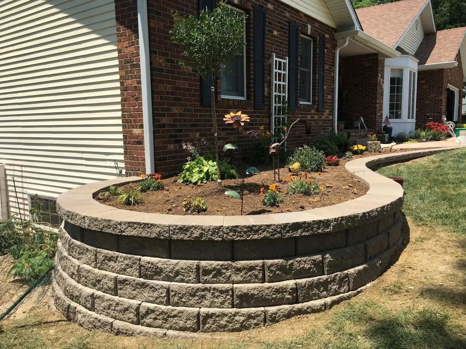 John's ProCare retaining wall built with stone blocks around a landscaped garden